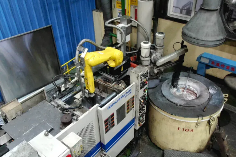 6軸ロボットアームと連携した芝浦製高圧アルミ合金ダイカストマシン、自動ラドル供給と高精度射出を実現